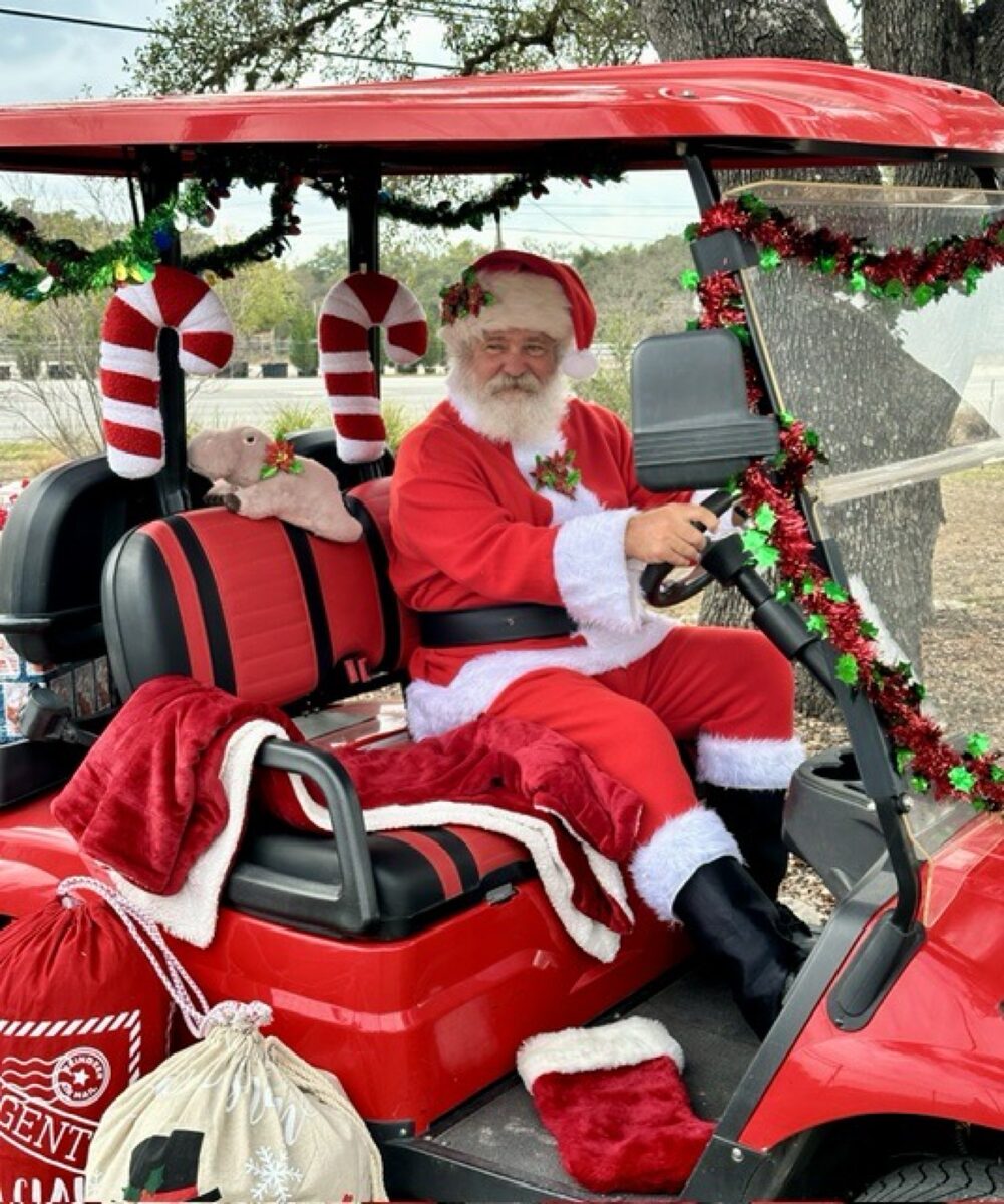 Santa driving a festive red golf cart decorated for Christmas